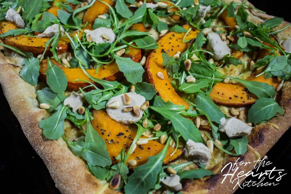 White Pizza mit karamellisiertem Kürbis, veganen Ziegenfrischkäsetupfen, Cashew Mascarpone, Rucola und gerösteten Pinienkernen