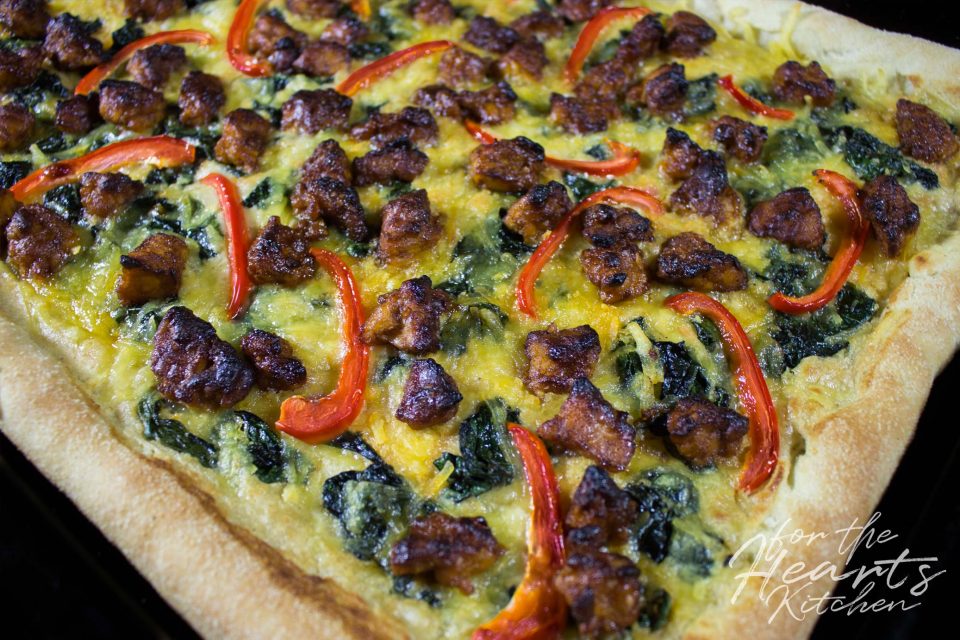 White Pizza mit spicy Buffalo Tempeh, Würzspinat, Paprikastreifen und Cashew Mascarpone